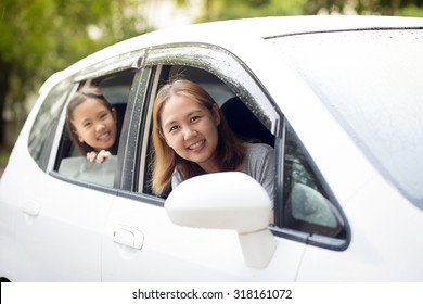 Happy Asian Family Sitting In The Car