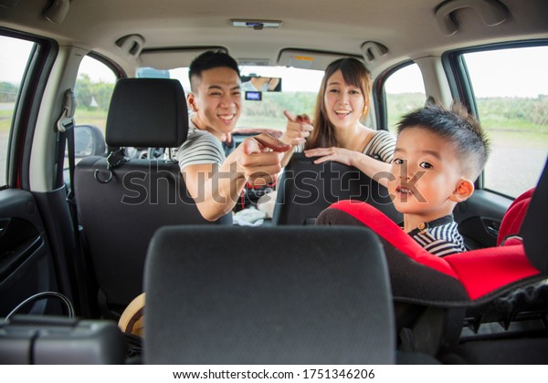 happy asian family\
sitting in the car