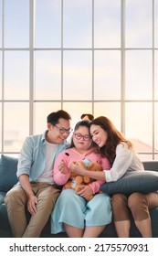 Happy Asian Family Sitting On Sofa And Playing Dolls With Their Daughter Down Syndrome Child In Living Room At Morning Time, Activity Happy Family Lifestyle Concept,