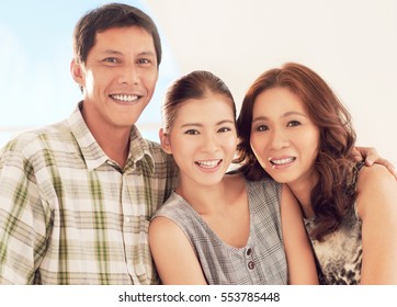 A Happy Asian Family Smiling And Posing For Photographing.