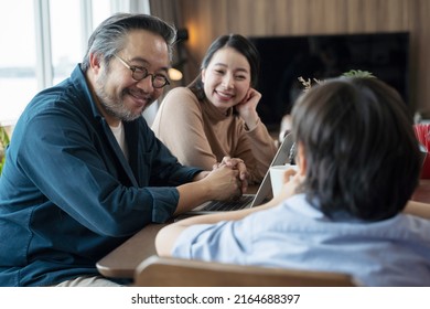 Happy Asian Family Spending Time Together In Living Room. Family And Home Concept.