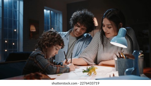 Happy asian family spending time at home together  Young parents teaching their little kid and curly hair how to draw  having fun    happy family  togetherness concept