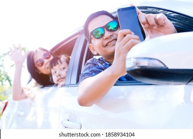 Happy Asian Family Taking Selfie In Car