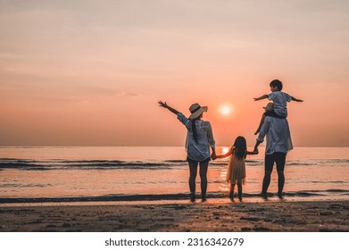 Happy asian family that enjoys beach activities during the summer holidays. Parent and children enjoy the sunset sea on beach. Summer vacations and Holiday travel conceps.  - Powered by Shutterstock