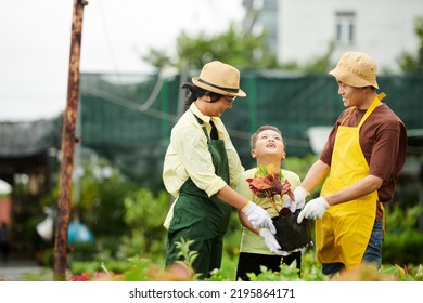 Happy Asian Family Of Three Working At Flower Nursery Together