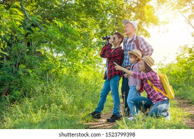 Happy Asian Family Trekking In Forest Together On Vacation.