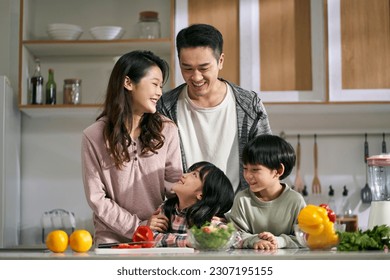 happy asian family with two children enjoying a good time together in kitchen at home - Powered by Shutterstock