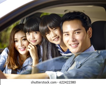 Happy Asian Family With Two Children Riding In A Car