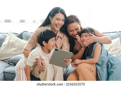 Happy Asian family using digital tablet in living at home, relaxing at home for lifestyle concept. - Powered by Shutterstock