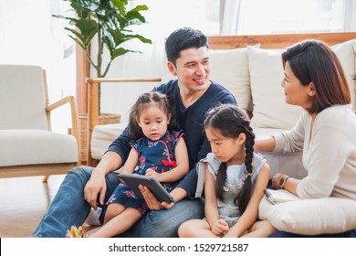 Happy Asian family using tablet, laptop for playing game watching movies, relaxing at home for lifestyle concept - Shutterstock ID 1529721587