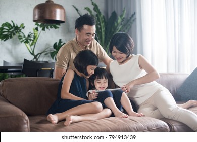 Happy Asian Family Using The Tablet Together At Home.