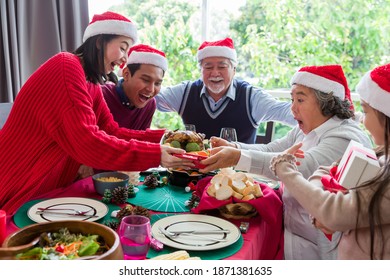 Happy Asian Family Wearing Santa Red Hat Have Lunch Together On Christmas Day At Home. Merry Christmas And Happy Holidays. Christmas Holiday Celebration