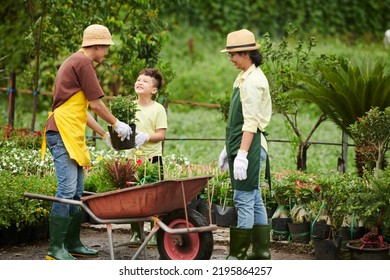 Happy Asian Family Working At Their Outdoor Plant Shop Together