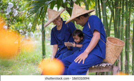 Happy Asian Family,Young Thai Farmer Lifestyle,communication From Mobile Phone,activity In Organic Farm,technology In Rural Area Concept.