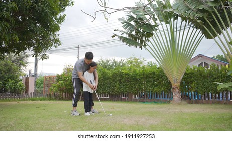 Happy Asian Father And Daughter Golfing Together On A Summer Day Riding In A Golf Cart Together In The Course, Difficult Time Stay Together In The Family Outdoor Concept On Green Park.