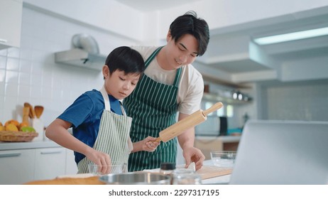 Happy Asian father teaching son cooking baking cake or cookie in kitchen. Happy family in kitchen - Powered by Shutterstock