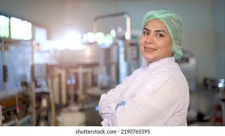 Happy Asian female portrait in manufacturing factory smiling - arm crossing and looking at the camera. Senior professional woman staff or worker in factory showing a thumb up and making arm crossed. - Powered by Shutterstock