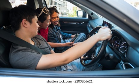 Happy Asian friends check map on GPS application on smartphone in suv car for their summer road trip. - Shutterstock ID 2203206621