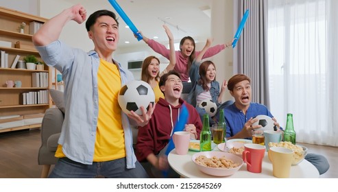 happy asian friends cheer with thundersticks drink beer watching live streaming soccer game while scoring goals - Shutterstock ID 2152845269