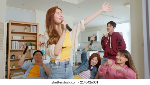 happy asian friends singing karaoke together in the room the brown long hair woman with microphone eye closed wave hands - Powered by Shutterstock