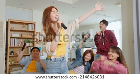 happy asian friends singing karaoke together in the room the brown long hair woman with microphone eye closed wave hands