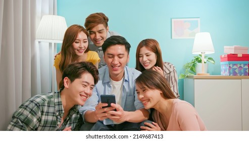 Happy Asian Friends Watching Funny Content On Internet Laughing Together When Man Holding Smartphone - Portrait Mobile