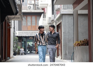 Happy Asian gay couple walking together in an urban alleyway, enjoying each other's company. - Powered by Shutterstock