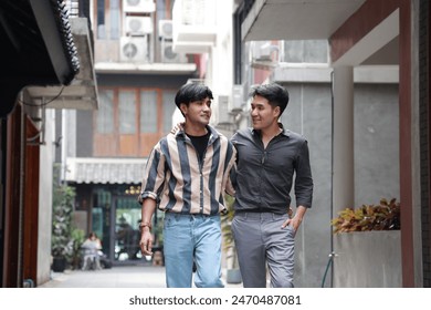 Happy Asian gay couple walking together in an urban alleyway, enjoying each other's company. - Powered by Shutterstock