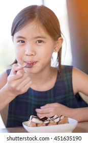 Happy Asian Girl Enjoy Eating Banana Split Ice-cream With Honey Toast.