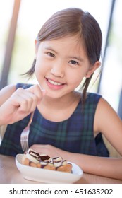 Happy Asian Girl Enjoy Eating Banana Split Ice-cream With Honey Toast.