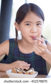 Happy Asian Girl Enjoy Eating Banana Split Ice-cream With Honey Toast.