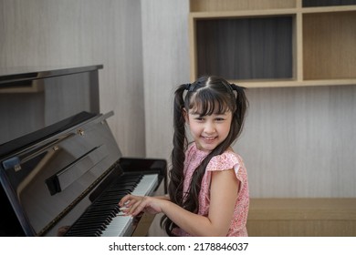 Happy Asian Girl Playing Piano.