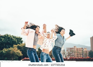 Happy Asian Girls Jumping Together Outdoor - Young Women Friends Having Fun During University Break Dancing And Celebrating Outside - Millennial Generation, Friendship And Youth People Lifestyle