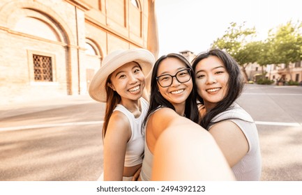 Happy asian girls taking selfie picture walking on city street - Group of Japanese young women enjoying summertime vacation - People, tourism and modern technology life style concept - Powered by Shutterstock