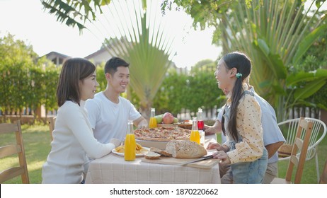 Happy Asian Grandchild Drinking Juice Grandpa. Multi Generation Family Enjoying Meal. They Having Outdoor Party Eating Food At Backyard Home, Lifestyle Family Concept Party At Summer Garden.