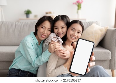 Happy Asian Grandmother, Mother And Daughter Embracing And Showing Big Blank Smartphone While Sitting Together At Home, Multi-generation Family Recommending New Mobile App Or Website, Collage, Mockup