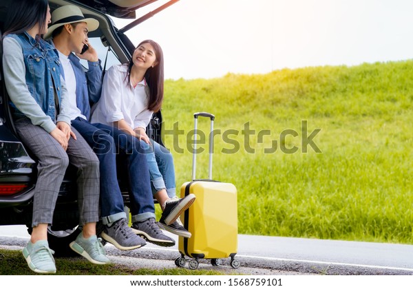 Happy asian group of friends with car travel driving and\
suitcase at mountain road and street in vacation summer road trip\
on holidays to destination, Traveler transportation vehicle people\
lifestyle 