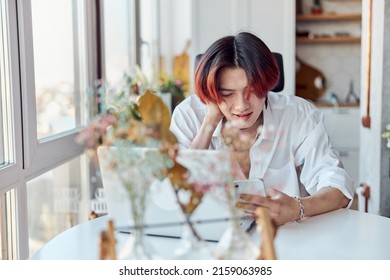 Happy Asian Guy Holding Smartphone While Chatting Online