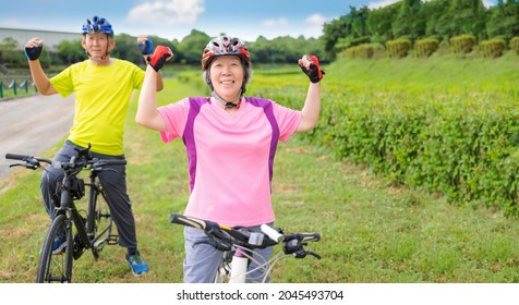 Happy Asian Healthy Senior Couple Exercising With Bicycles