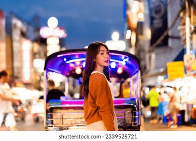 Happy Asian holiday travel vacation. Young woman outdoor city lifestyle shopping and eating street food together at Bangkok Chinatown street night market