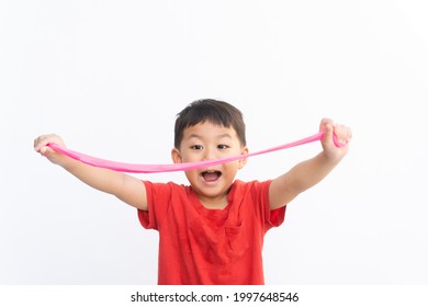 Happy Asian Kid Boy Looking Fun To Play Pink Slime.Kindergarten Child With Red T Shirt Playing Science Craft Slime Toy.Child Fine Motor Development Skills.Montessori Kid Play Slime On Isolated White.