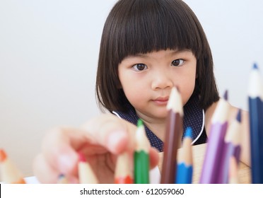 Happy Asian Kid Girl Selecting Color Pencil For Drawing Picture