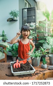 Happy Asian Kid Planting And Gardening Activity At Home By Herself