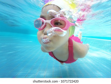 Happy Asian Kid Swimming Underwater In Summer. Outdoor Activities In Swimming Pool. Zoom Motion In Pool