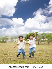 Happy Asian Kids Running On The Grass