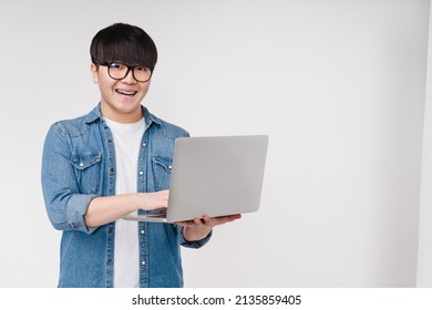 Happy asian korean young student man freelancer hacker working remotely on laptop, doing online shopping, e-learning on distance, browsing, e-commerce isolated on white background
