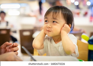 Happy Asian little boy covering his ears, smiling and hears nothing. Mother teaches children. The obstinate son refused to listen Concept of childhood.
