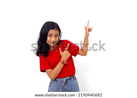Happy asian little girl standing while presenting something. Isolated on white background