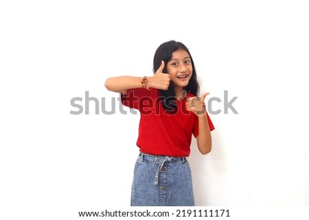 Happy Asian little girl standing while showing thumbs up.Isolated on white background with copyspace