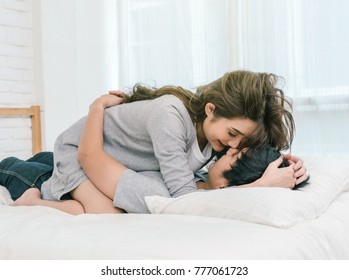 Happy Asian Lover kissing and hugging on the bed in bedroom at home, Couple and life style concept,
